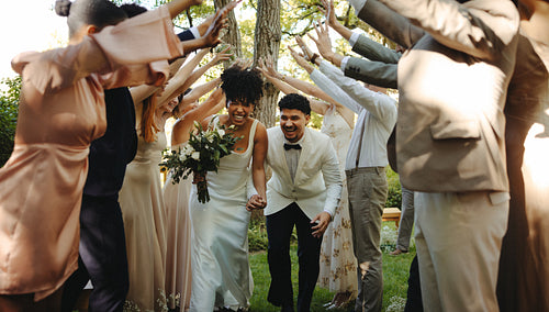 Bride and groom celebrate with friends during outdoor wedding ceremony