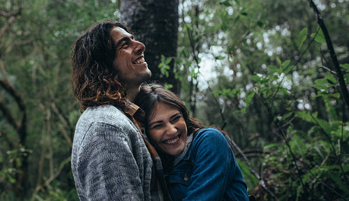 Couple having great time in forest during rain