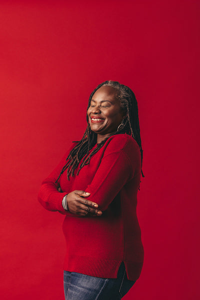 Carefree woman with dreadlocks smiling happily in a studio