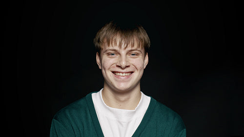 Man in casuals smiling on black background
