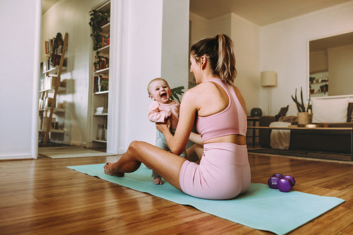 Cute little baby smiling excitedly in her mother's hands