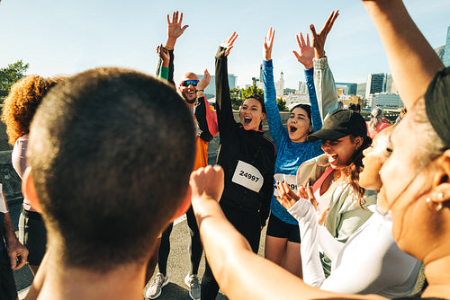 Group celebrating after finishing half marathon together outdoors