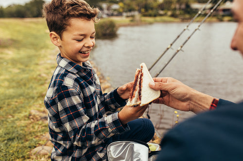 Father and son on a day out fishing near a lake