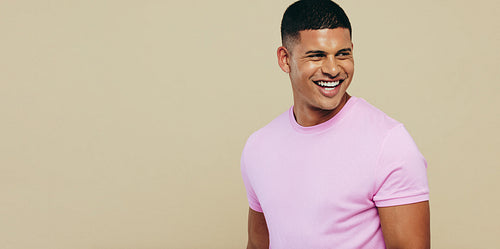 Young man proudly displaying his beautiful, flawless skin in a studio