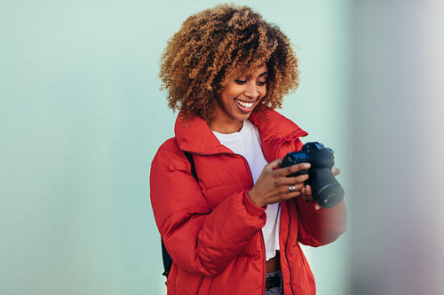 Portrait of a tourist woman looking at her dslr camera