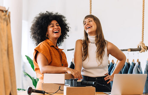 Cheerful online store owners laughing happily in their shop