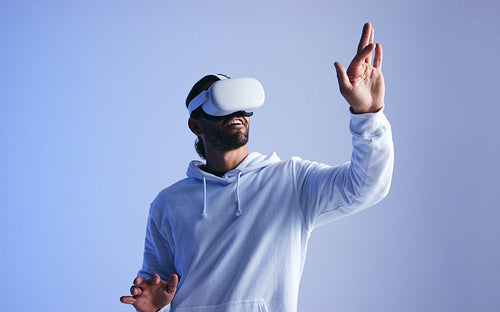 Happy young man experiencing a 3D simulation in a studio