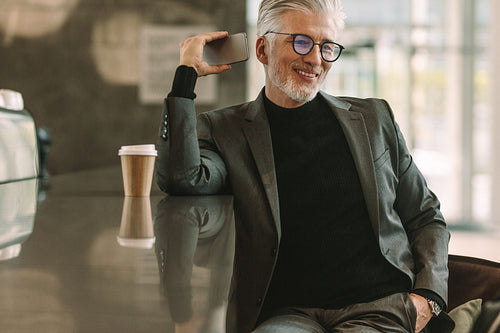 Businessman having conversation on phone in cafe