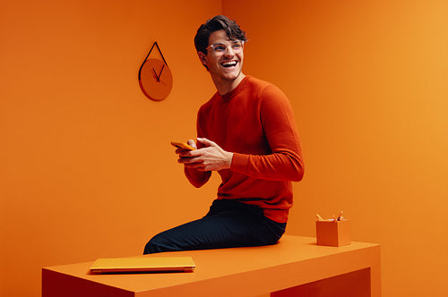 Successful marketing professional using smartphone in vibrant monochromatic office setup