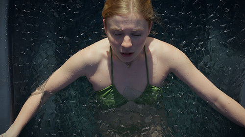 Woman in ice bath practicing cold plunge breathing for recovery and wellness indoors