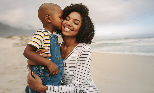 Son kissing his mother at the beach