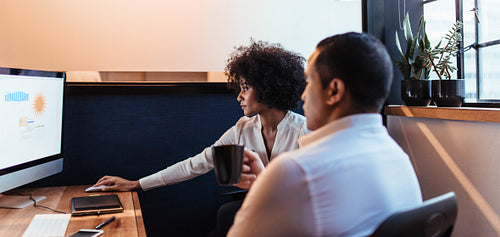 Two businesspeople looking together at computer