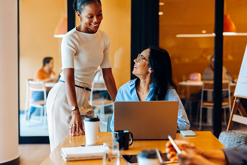 Two professional women interacting positively in an office environment