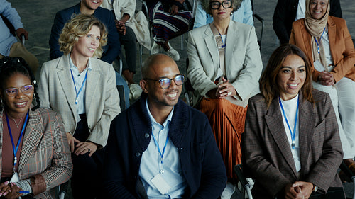 Diverse business professionals actively engage and smile while attending a stimulating conference presentation