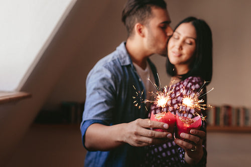 Sparklers on cupcakes in hand of couple