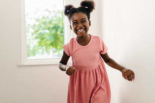 Cheerful afro-haired girl smiling and laughing at home