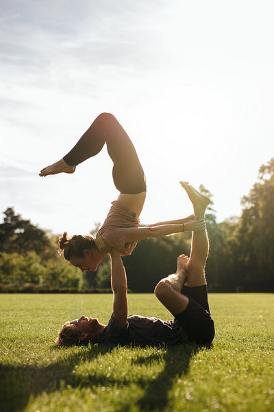 Young couple doing acrobatic pair yoga