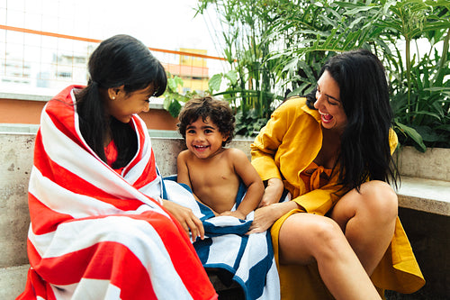 Happy family bonding moment with towels outdoors on a clear day