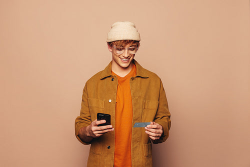 Happy man smiling while using a modern banking app on his smartphone