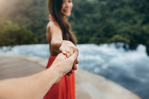 Couple holding hands near poolside