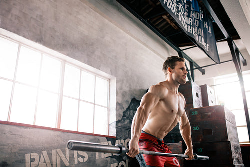 Muscular men lifting a barbell at the gym