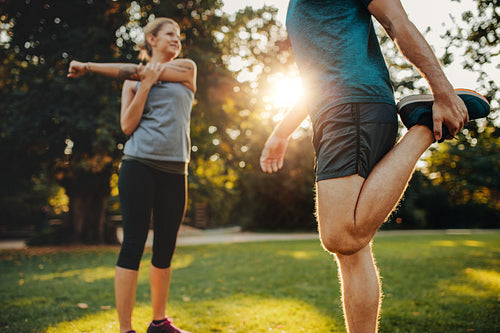 Young man and woman stretching in the park