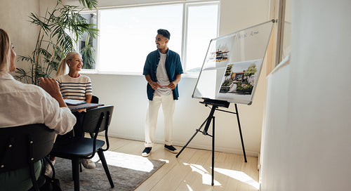 Architect presenting designs to team in a modern office setting