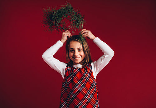Smiling girl holding twigs to her head