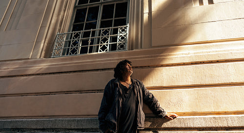 Contemplative homeless man looking up outdoors