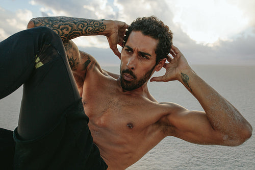 Male doing abs exercise in desert