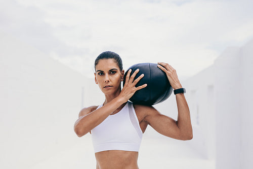 Woman in fitness wear doing fitness training using a medicine ball