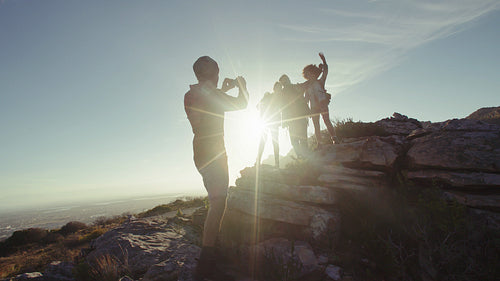 Man taking picture of his friends having fun during hike.
