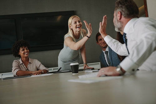 Business people giving a high five during meeting