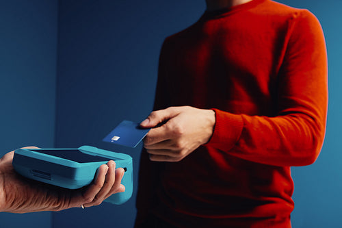 Customer making a cashless payment in vibrant colorful studio