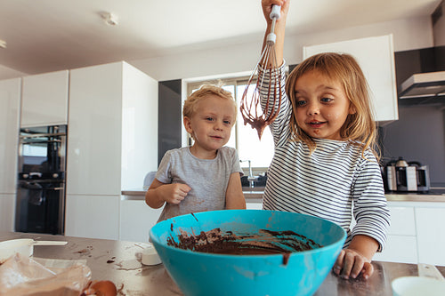 Kids preparing cake batter in kitchen