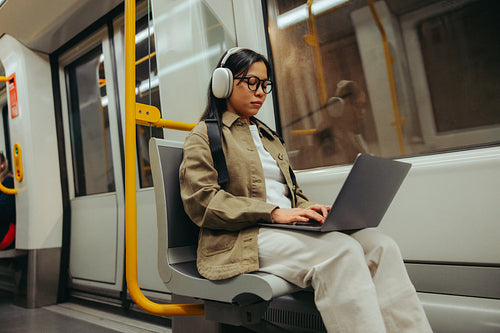 Commuter using laptop on subway during commute
