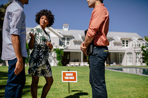 Young couple with real estate agent visiting house for sale