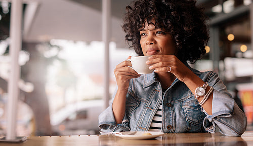 Pensive young female having coffee in a restaurant