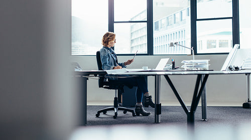 Businesswoman with digital tablet working at her desk