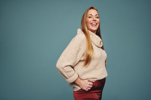 Smiling blonde woman looking at the camera in a studio