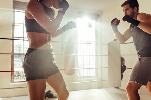 Two fighters facing each other in a boxing ring