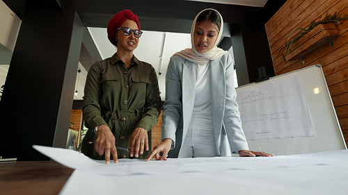 Women in headscarves working together on an architectural project