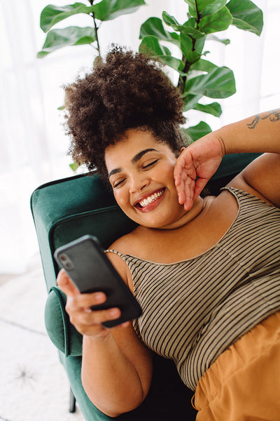 Woman using smart phone on sofa