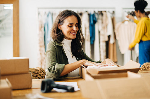 Business woman preparing orders for drop shipping in her clothing boutique