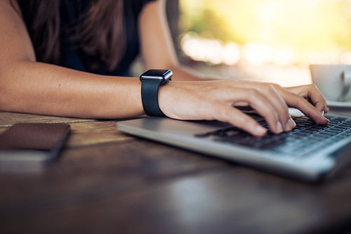 Woman with smartwatch working on laptop