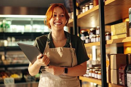 Cheerful grocery store owner smiling in her shop