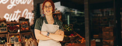 Successful supermarket owner smiling at the camera happily