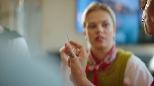 Gesturing women exchange feedback during a business meeting in a coworking cafe