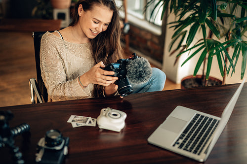 Female watching her recorded blog content on camera