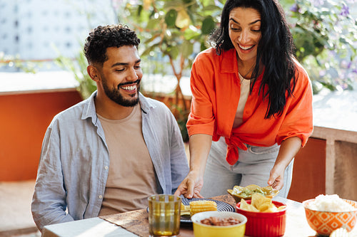 Smiling friends enjoying a cheerful meal together in an outdoor setting